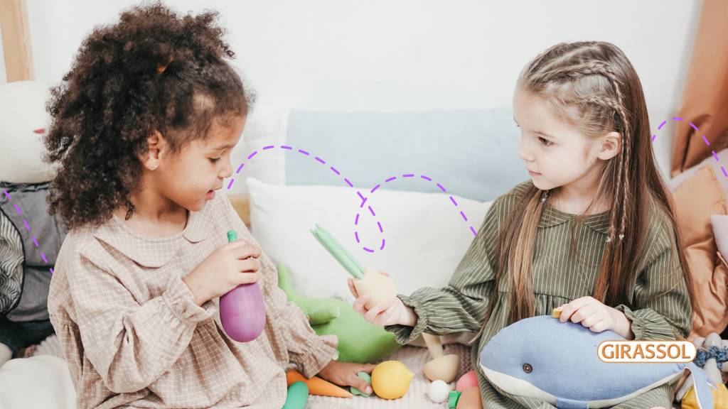 Criança empática dividindo os brinquedos com a amiga.